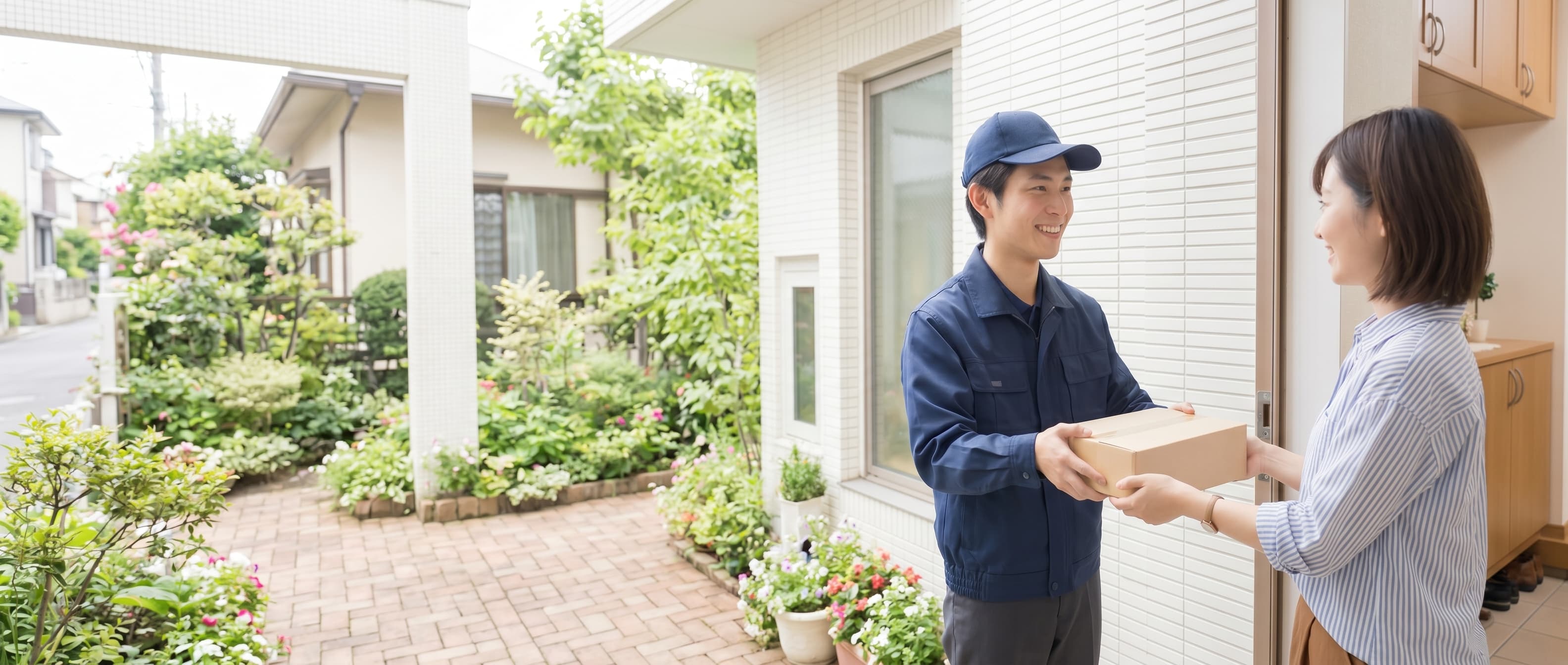 玄関で荷物を渡す配送スタッフ